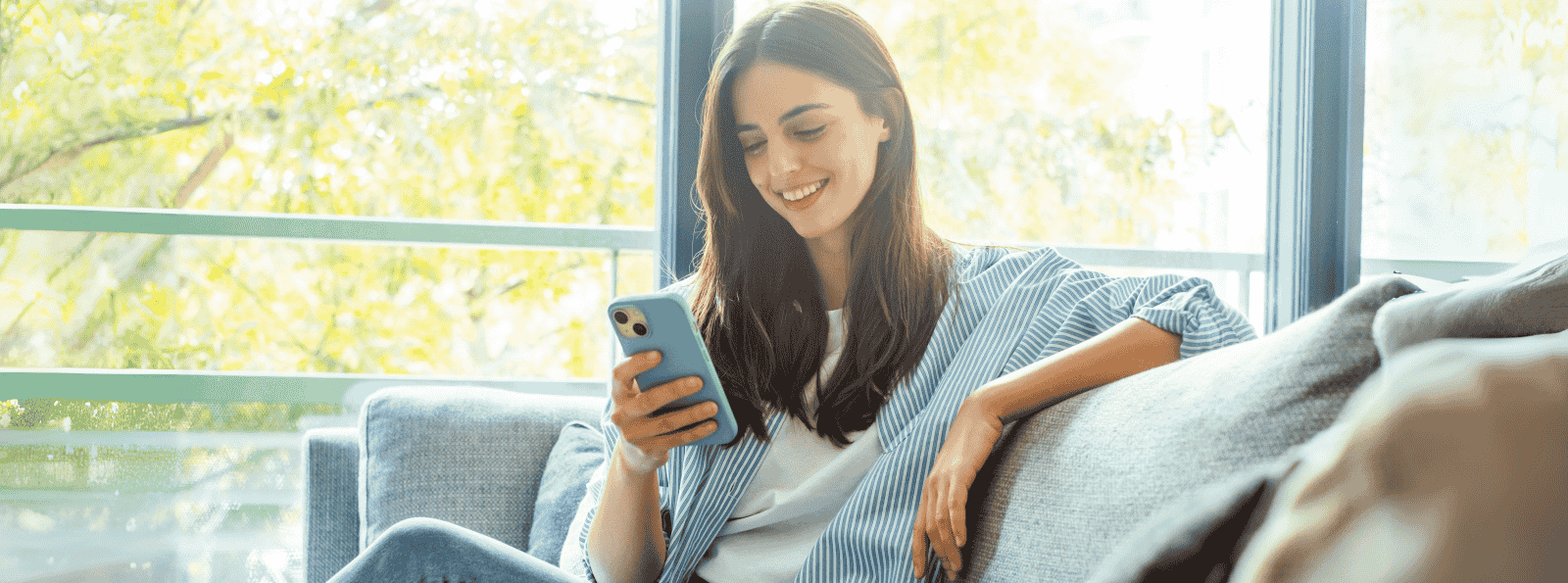 Woman smiling while looking at her mobile phone