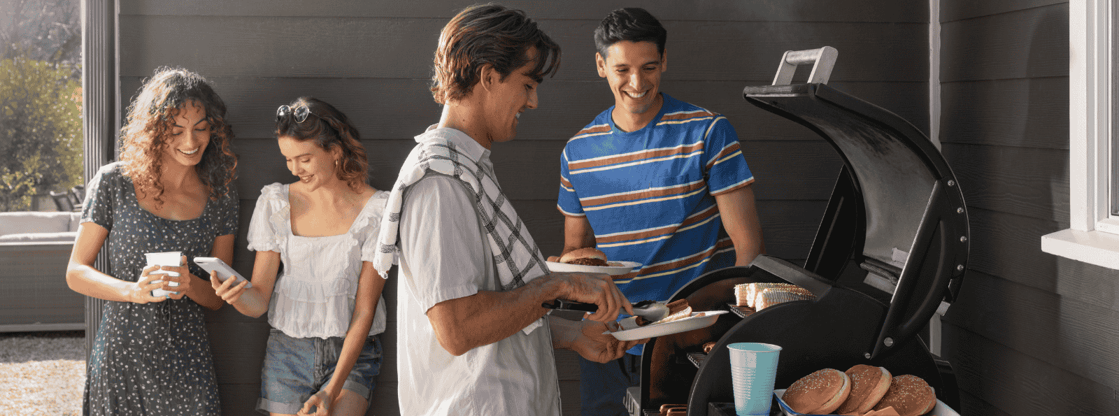 Group of 4 young people grilling hamburgers