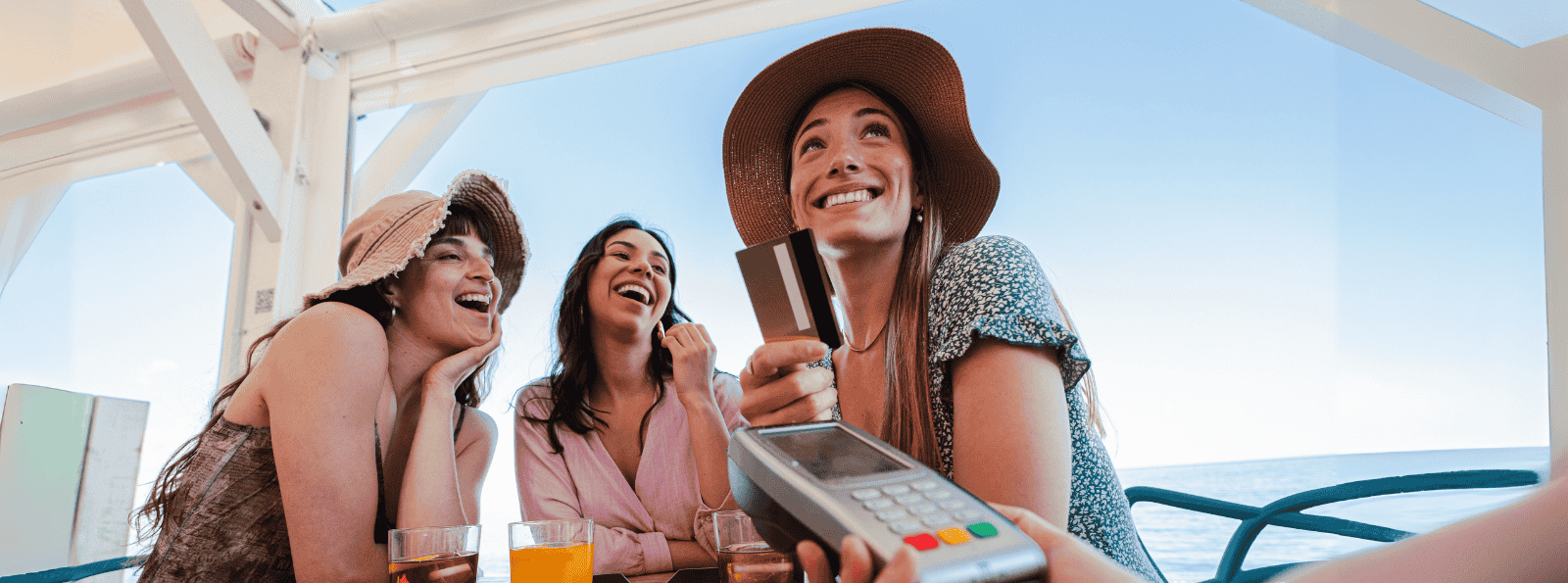 Group of Women paying for drinks at waterside restaurant