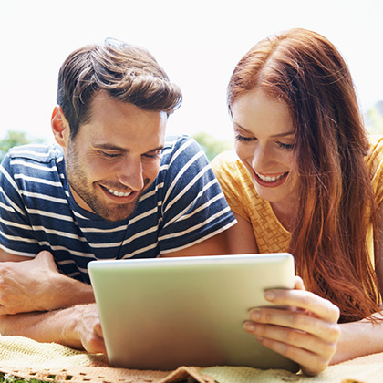 Couple looking at a tablet.