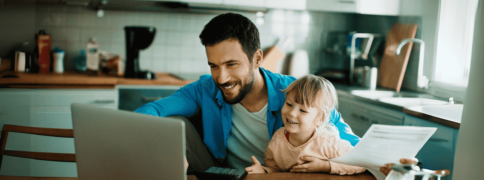Father paying bills online with daughter on his lap