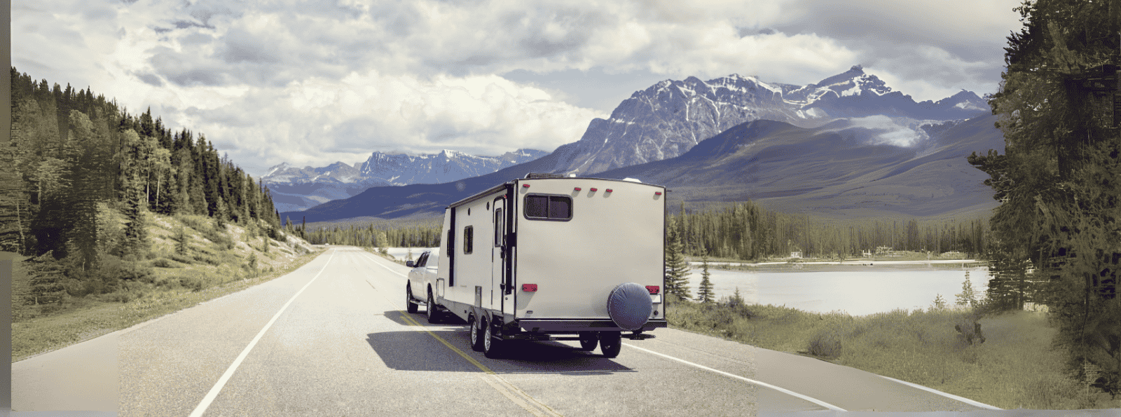 Truck pulling camp trailer through mountains
