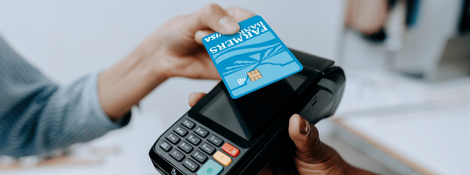 Woman tapping Farmers Bank credit card to pay at a terminal